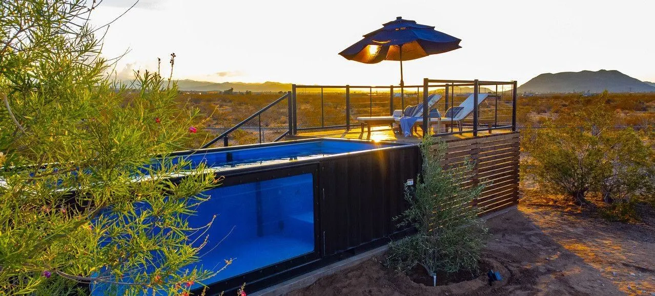 Custom shipping container converted into an in-ground pool with deck